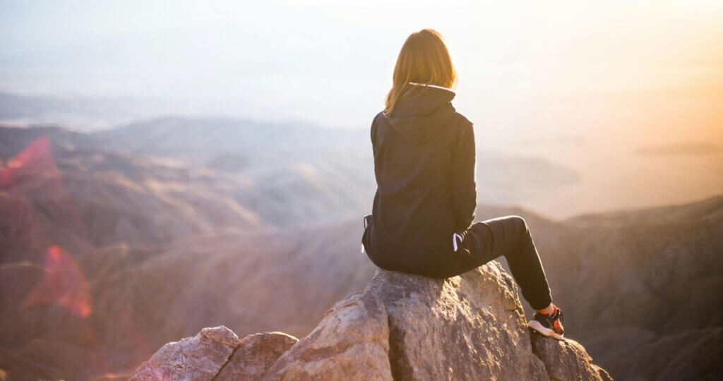 Woman sitting on a mountain top